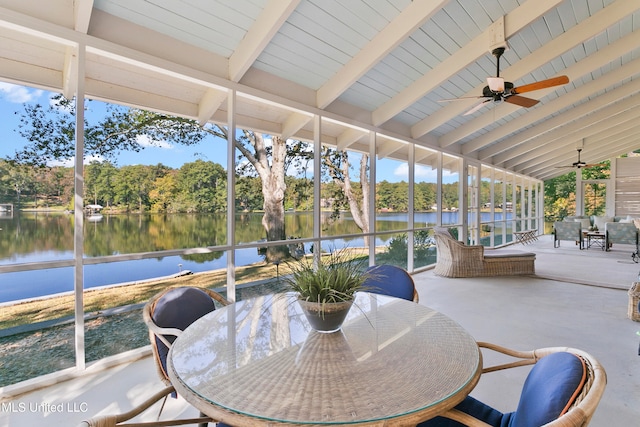 sunroom / solarium featuring vaulted ceiling with beams, a healthy amount of sunlight, a water view, and ceiling fan