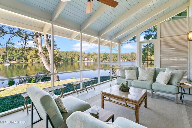 sunroom featuring a water view, ceiling fan, and vaulted ceiling with beams