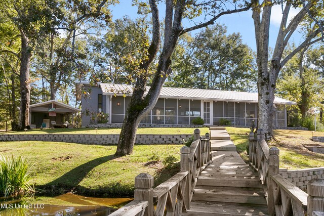 view of front of home with a front lawn and a sunroom