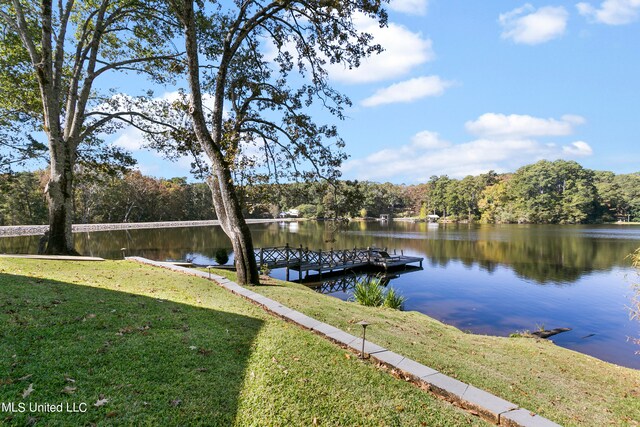 dock area featuring a water view and a lawn