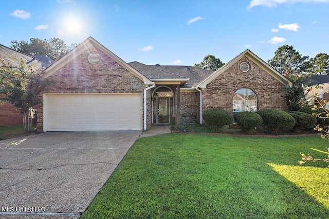 view of front of home with a front yard and a garage