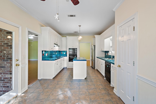 kitchen with dark tile patterned flooring, black appliances, sink, white cabinetry, and decorative light fixtures