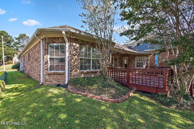 rear view of house featuring a wooden deck and a lawn