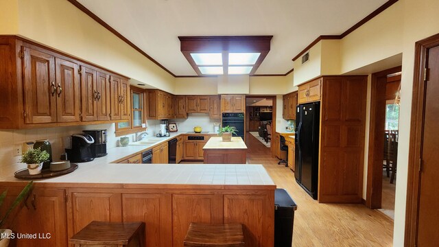 11 Aberdeen Rd, Natchez, MS 39120 - kitchen with black appliances, light countertops, light wood-style floors, a sink, and a peninsula