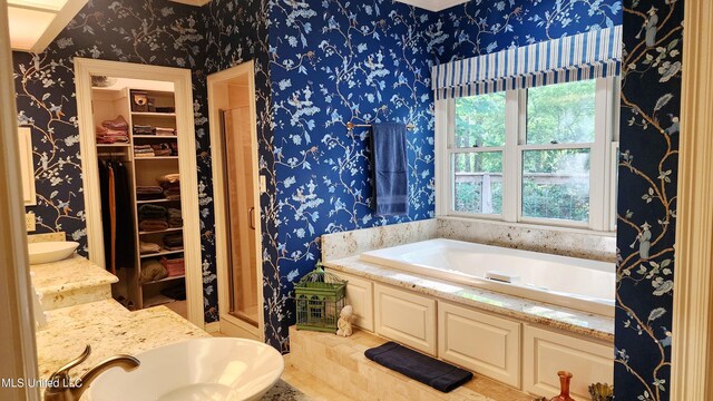 11 Aberdeen Rd, Natchez, MS 39120 - bathroom with wallpapered walls, a spacious closet, a sink, a garden tub, and a stall shower