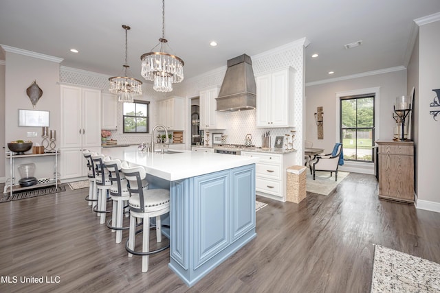 2011 Ivy Ct, Biloxi, MS 39532 - kitchen with custom exhaust hood, a sink, white cabinetry, crown molding, and light countertops