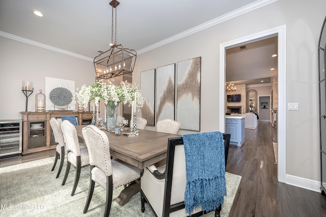 2011 Ivy Ct, Biloxi, MS 39532 - dining area featuring a notable chandelier, beverage cooler, baseboards, crown molding, and wood finished floors