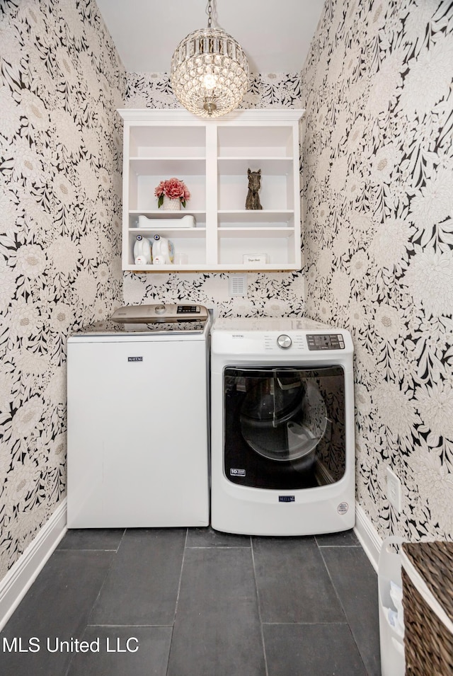 2011 Ivy Ct, Biloxi, MS 39532 - clothes washing area with wallpapered walls, baseboards, washer and dryer, dark tile patterned flooring, and laundry area