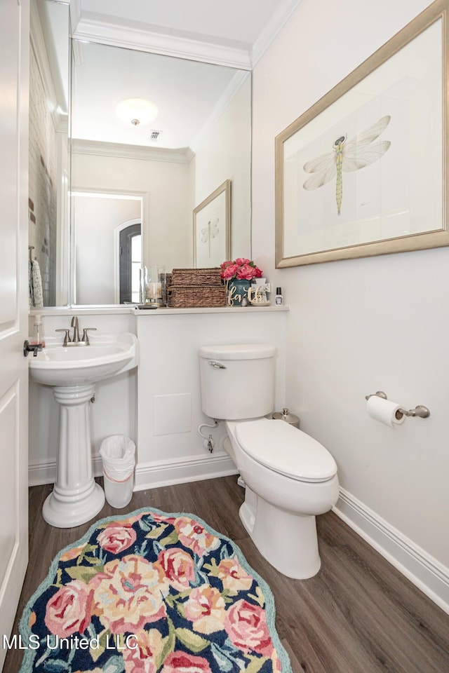 2011 Ivy Ct, Biloxi, MS 39532 - half bath with toilet, baseboards, visible vents, crown molding, and wood finished floors