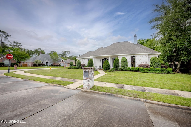 2011 Ivy Ct, Biloxi, MS 39532 - view of front of home featuring a shingled roof, a front lawn, and a chimney
