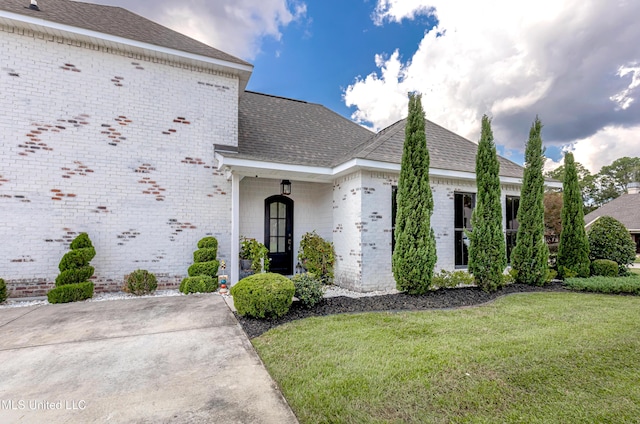 2011 Ivy Ct, Biloxi, MS 39532 - view of front of property with a shingled roof, a front lawn, and brick siding