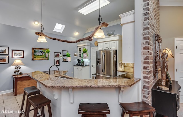3 Carriage Court Pl, Brandon, MS 39047 - kitchen featuring stainless steel refrigerator with ice dispenser, a sink, light stone countertops, light tile patterned flooring, and a skylight