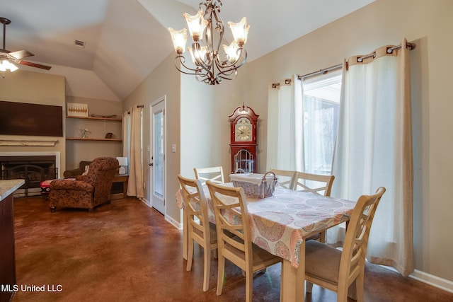 dining space with ceiling fan with notable chandelier, a fireplace, visible vents, concrete flooring, and lofted ceiling