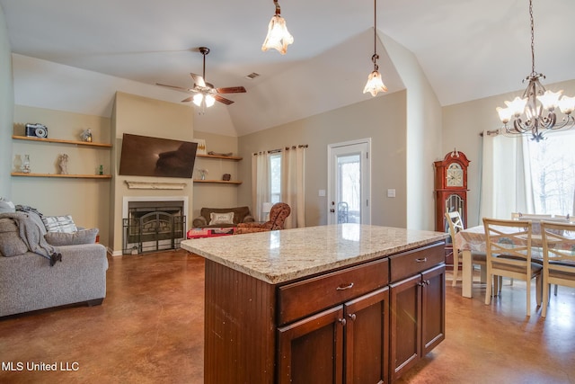 kitchen featuring a fireplace, concrete floors, vaulted ceiling, and decorative light fixtures