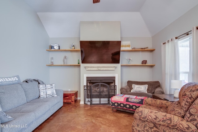 living area featuring lofted ceiling, concrete floors, and a fireplace