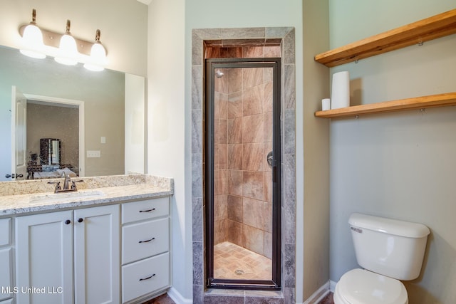 bathroom with toilet, a stall shower, and vanity