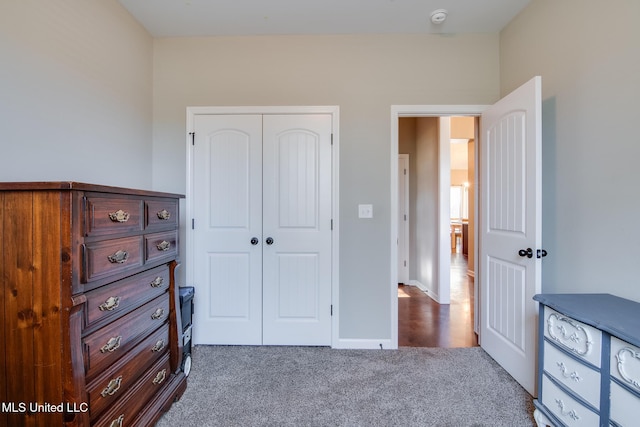 carpeted bedroom featuring a closet and baseboards