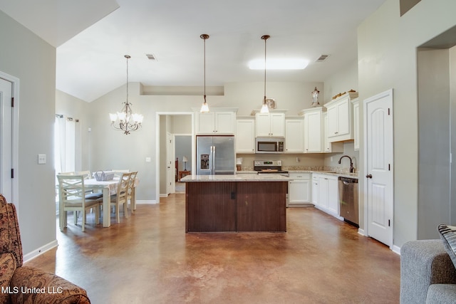 kitchen with finished concrete flooring, a sink, stainless steel appliances, a kitchen island, and baseboards