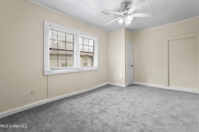 carpeted spare room with ceiling fan and ornamental molding