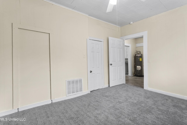 unfurnished bedroom with carpet flooring, electric water heater, and ceiling fan