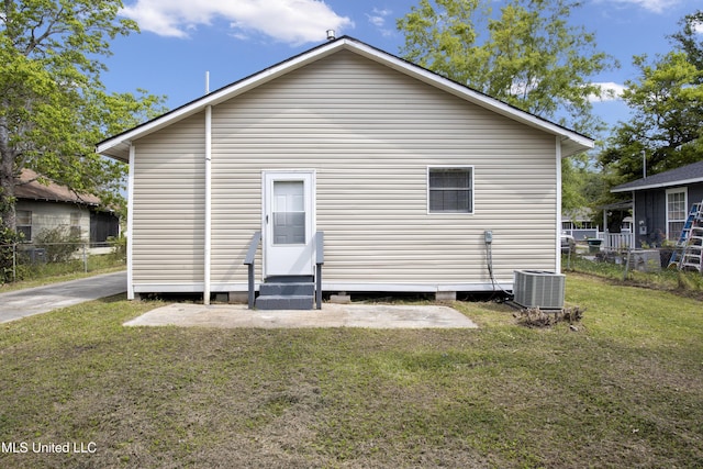 back of property featuring a lawn and central air condition unit