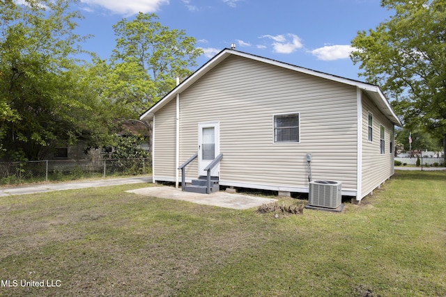 rear view of house with a yard and cooling unit