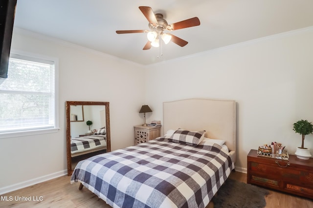 bedroom featuring light wood finished floors, ceiling fan, crown molding, and baseboards