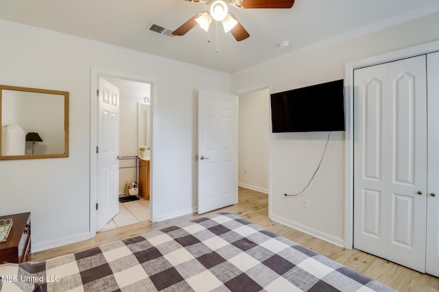 unfurnished bedroom featuring visible vents, baseboards, ornamental molding, light wood-style floors, and a closet