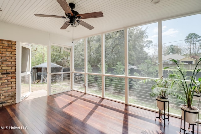 unfurnished sunroom with a healthy amount of sunlight and a ceiling fan