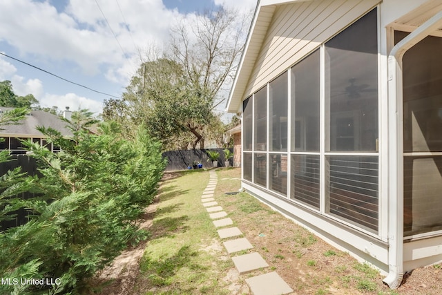 view of yard featuring a sunroom and fence