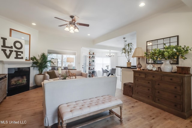 interior space with recessed lighting, light wood-style flooring, a fireplace, and an inviting chandelier