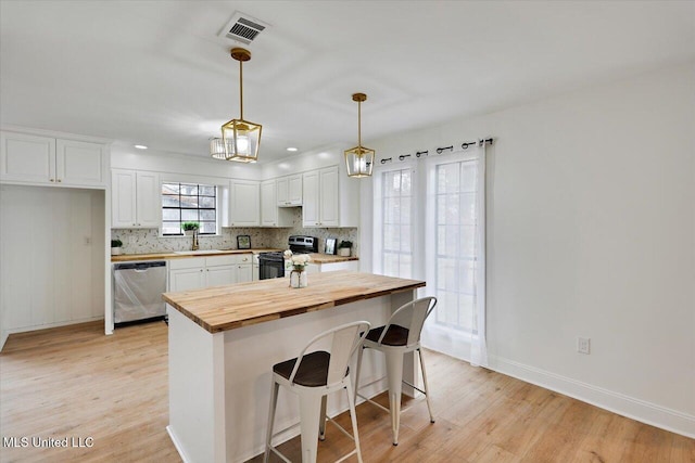 1505 Rosemont Dr, Clinton, MS 39056 - kitchen featuring dishwasher, butcher block countertops, range with electric stovetop, light wood-style flooring, and white cabinets