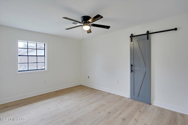 1505 Rosemont Dr, Clinton, MS 39056 - unfurnished bedroom featuring light wood-style flooring, baseboards, a barn door, and a ceiling fan