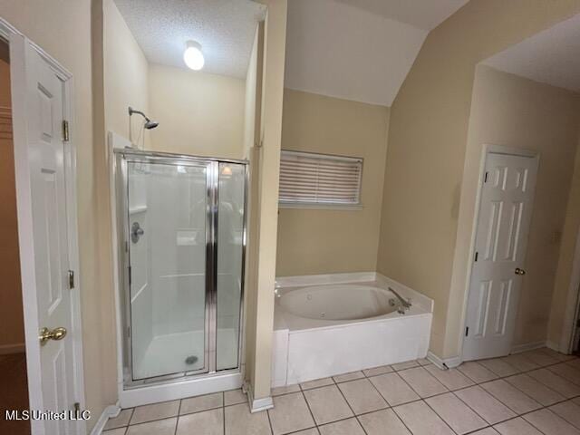 bathroom featuring a textured ceiling, tile patterned floors, and separate shower and tub