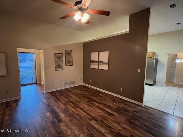 spare room with vaulted ceiling, wood-type flooring, and ceiling fan