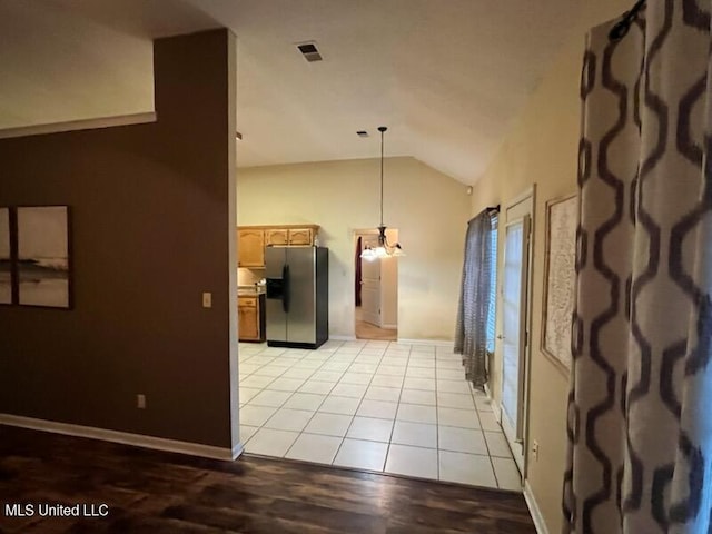 interior space featuring a chandelier, vaulted ceiling, and light tile patterned floors