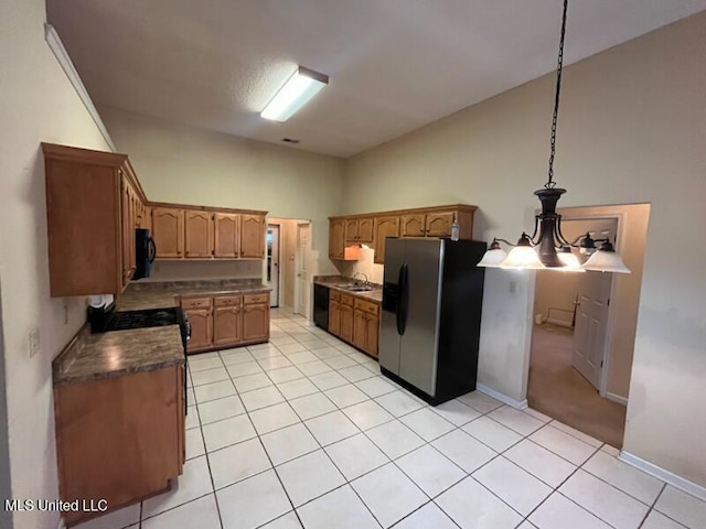 kitchen with sink, light tile patterned floors, stainless steel fridge, high vaulted ceiling, and decorative light fixtures