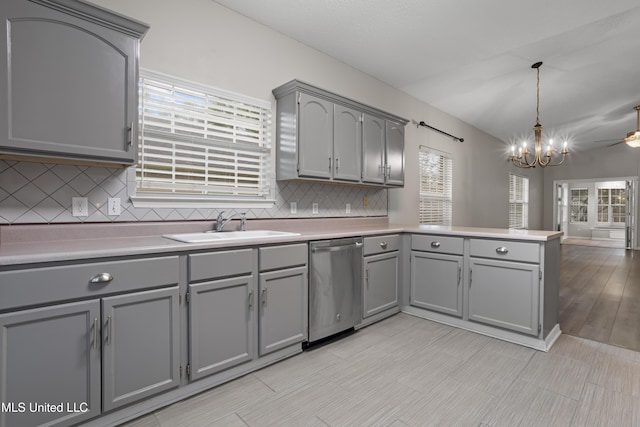 kitchen featuring gray cabinets, stainless steel dishwasher, a peninsula, and a sink
