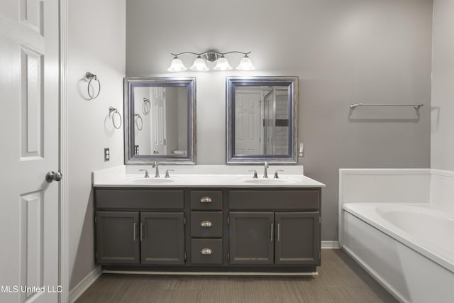 bathroom with double vanity, baseboards, and a garden tub