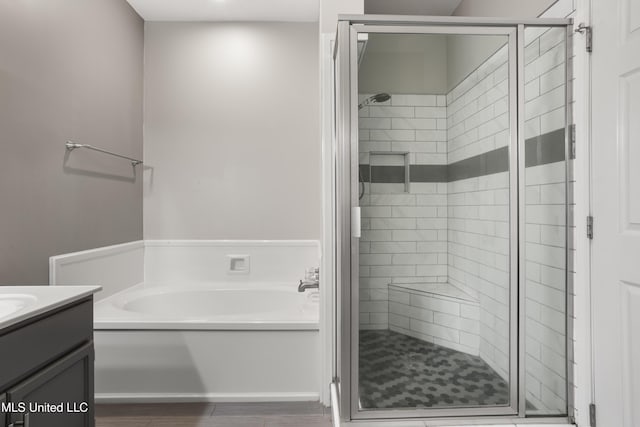 full bathroom featuring vanity, a stall shower, and a garden tub