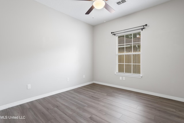 empty room featuring a ceiling fan, wood finished floors, and baseboards