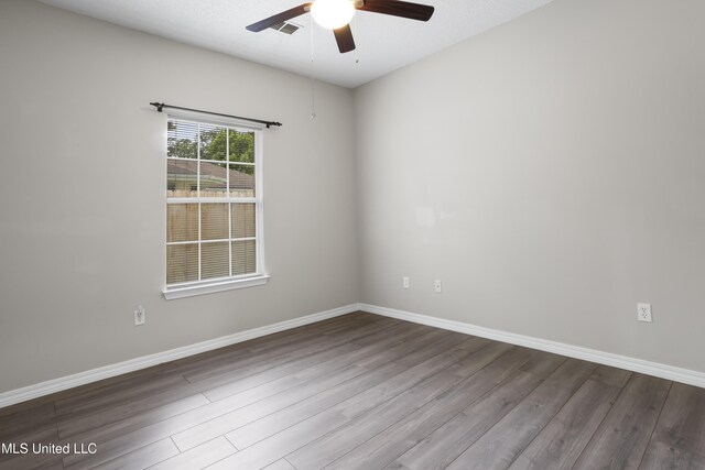 spare room featuring ceiling fan, wood finished floors, and baseboards