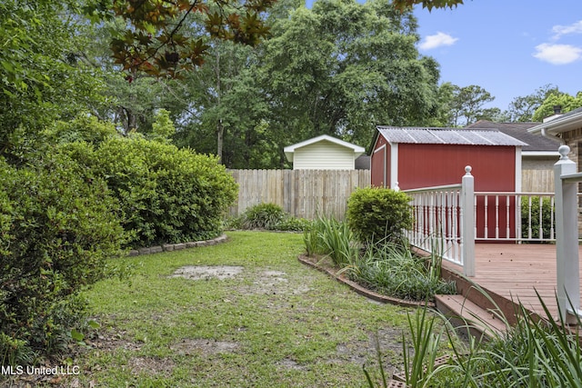 view of yard featuring a wooden deck and an outbuilding
