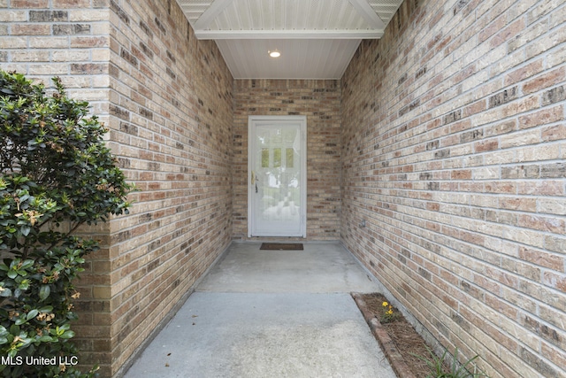 view of exterior entry featuring brick siding
