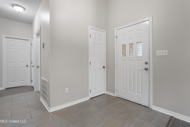 foyer entrance featuring wood finish floors and baseboards