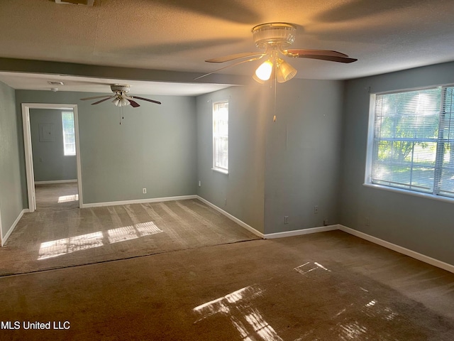 carpeted spare room featuring ceiling fan and a textured ceiling