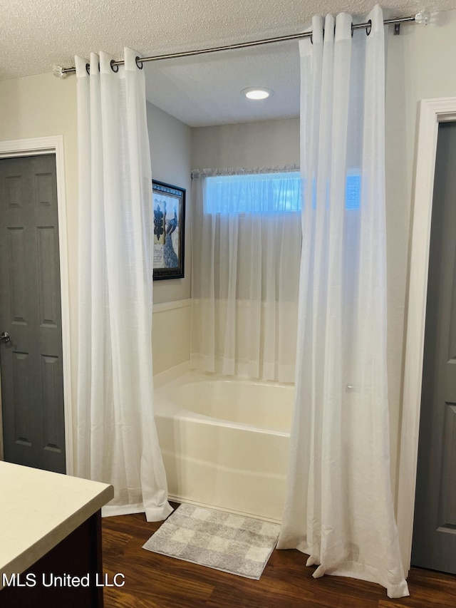 bathroom with wood finished floors, a textured ceiling, and vanity
