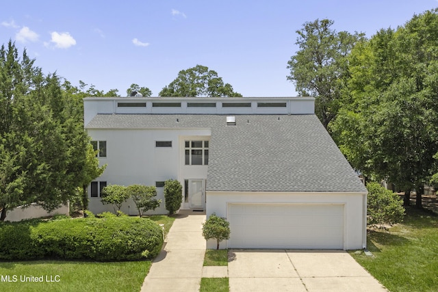 11 Bayou Pl, Gulfport, MS 39503 - mid-century modern home with driveway, roof with shingles, an attached garage, and stucco siding