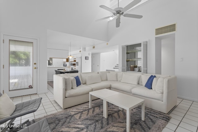 11 Bayou Pl, Gulfport, MS 39503 - living room with light tile patterned floors, stairs, high vaulted ceiling, ceiling fan, and baseboards