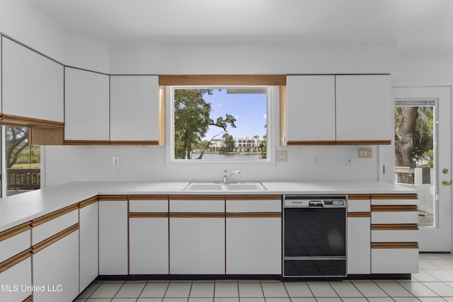 11 Bayou Pl, Gulfport, MS 39503 - kitchen featuring black dishwasher, a sink, light countertops, white cabinets, and light tile patterned floors